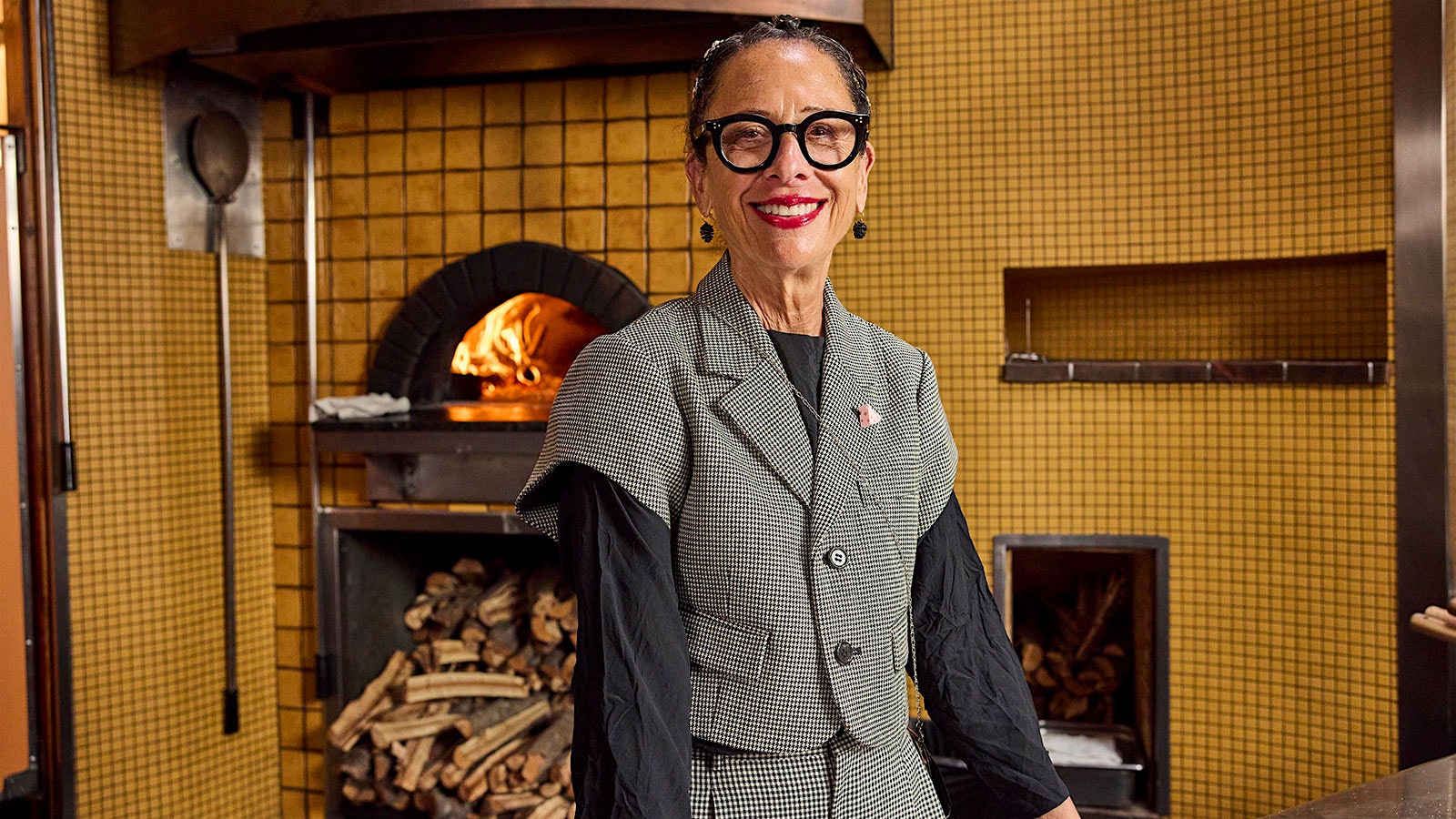 Chef Nancy Silverton in front of a wood-fire pizza oven.
